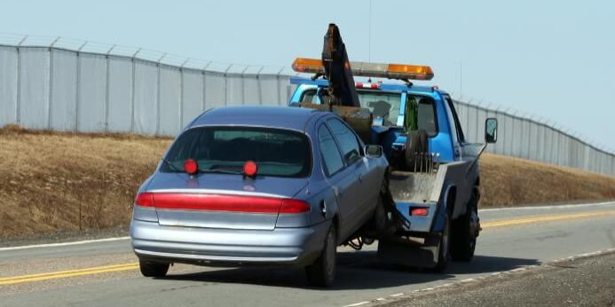 Towtruck Towing On Road With Fence